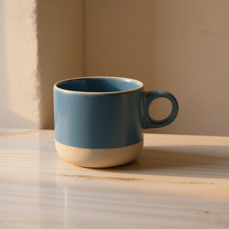 Dipped Stoneware Handmade Mug on a marble counter in a cream plaster niche with warm morning light