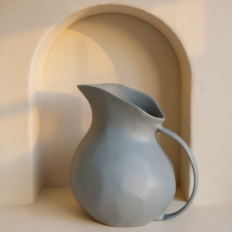 Matte Grey Aluminum Handled Vase in a cream plaster niche with warm natural side light