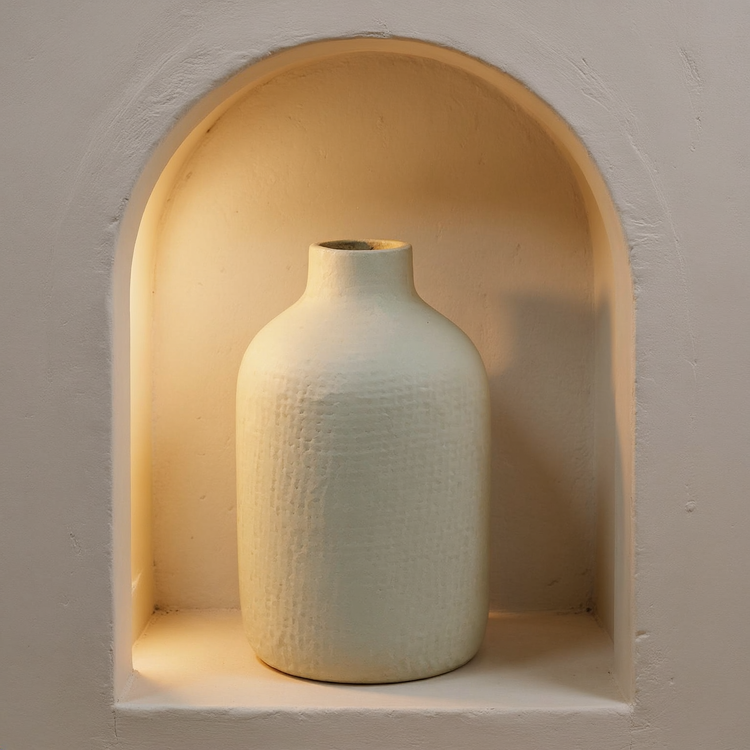 Textured Off-White Aluminum Vase in a cream plaster niche with warm natural side light