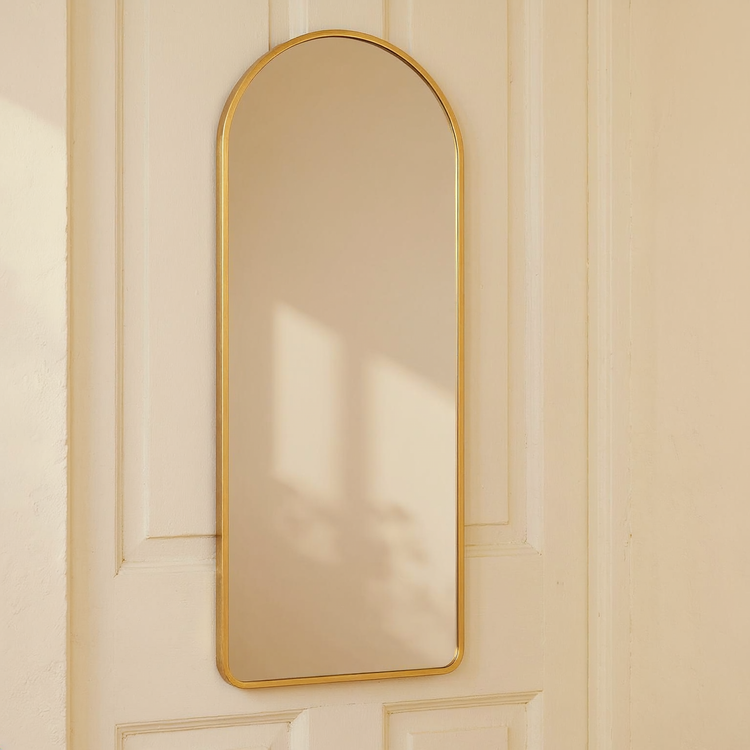 Gold Arched Over-Door Full-Length Mirror against a cream limewash wall with warm natural side light