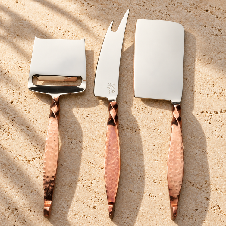 Hammered Copper-Handle Cheese Knife Set on a sunlit pale travertine counter