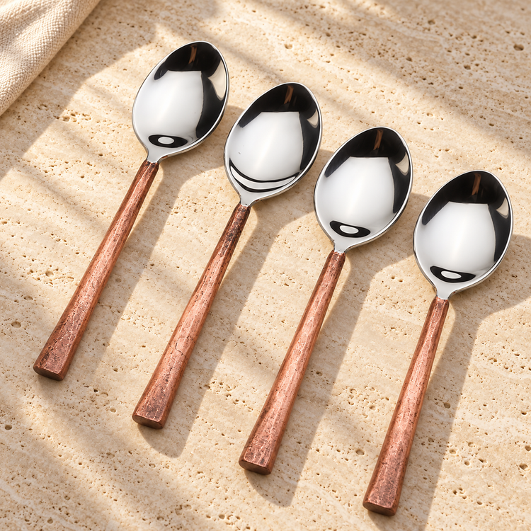 Copper-Handle Stainless Steel Table Spoon Set on a sunlit pale travertine counter