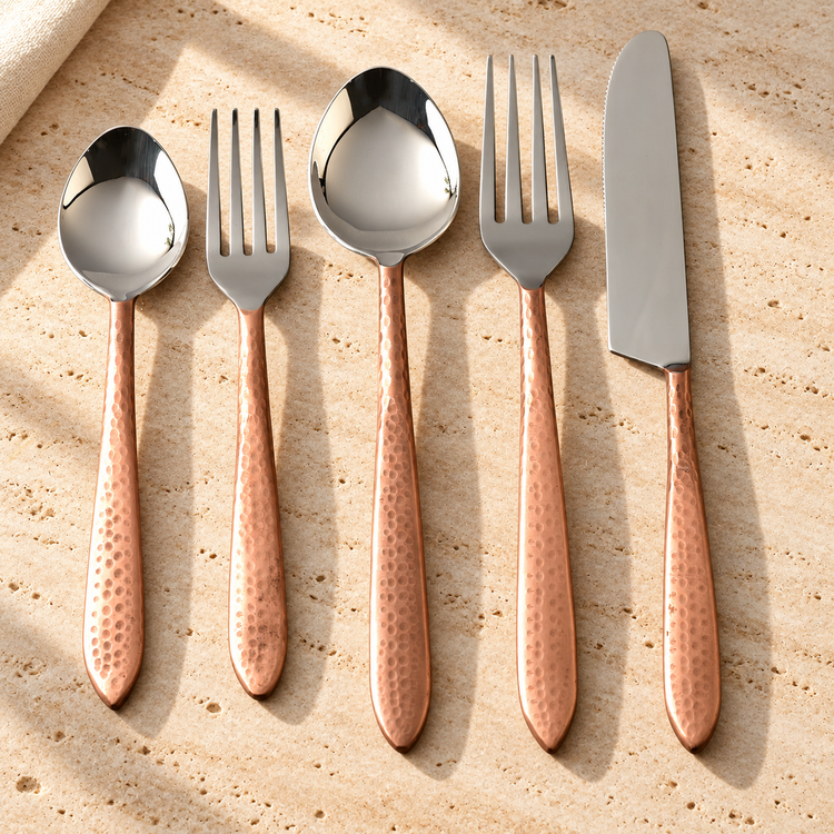 Hammered Stainless Steel Flatware Set on a sunlit pale travertine counter