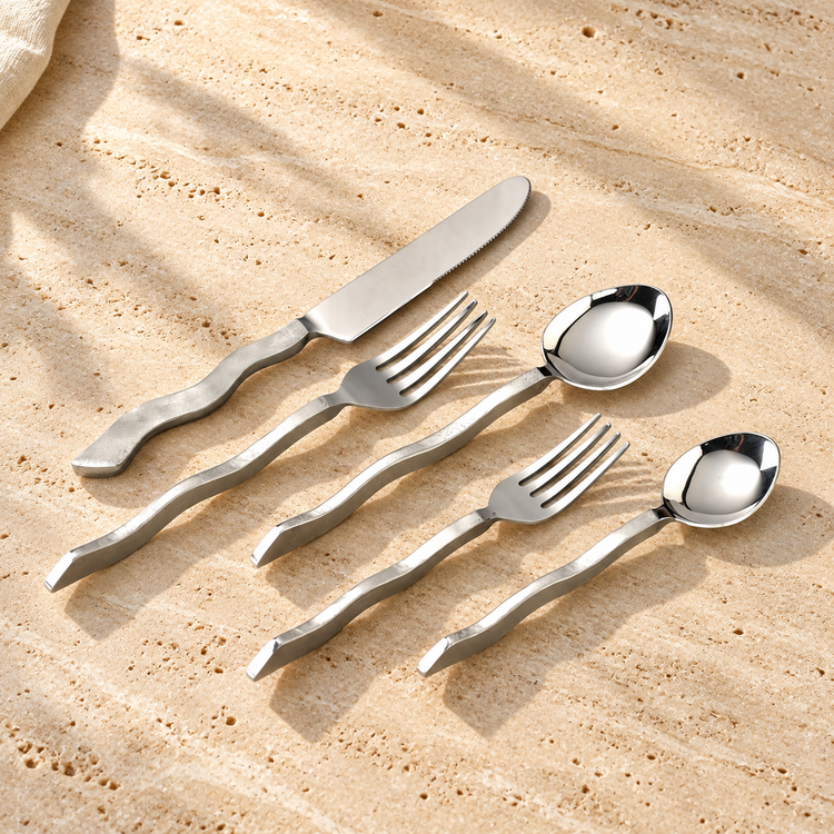 Wavy Handle Stainless Flatware Set on a sunlit pale travertine counter