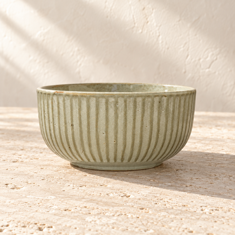 Cream Glazed Ribbed Stoneware Serving Bowl on a sunlit pale travertine counter