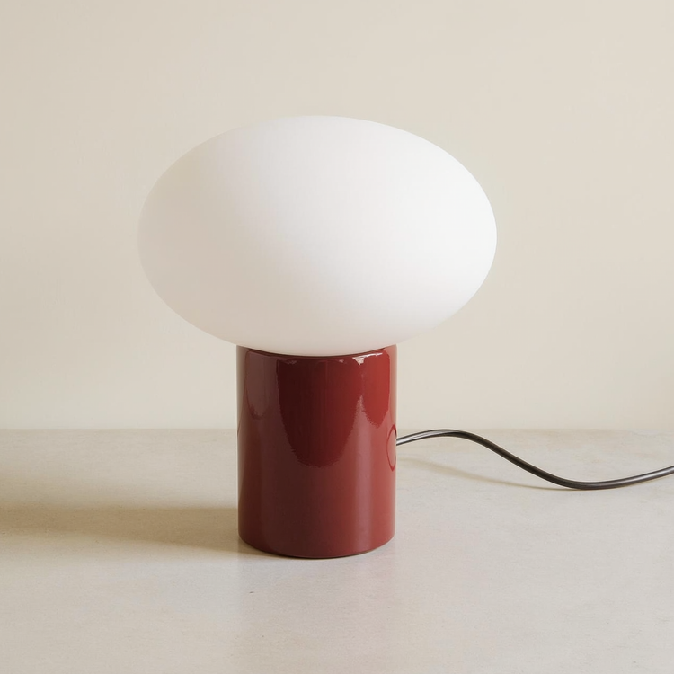 Frosted Globe Oval Table Lamp on a neutral concrete tabletop