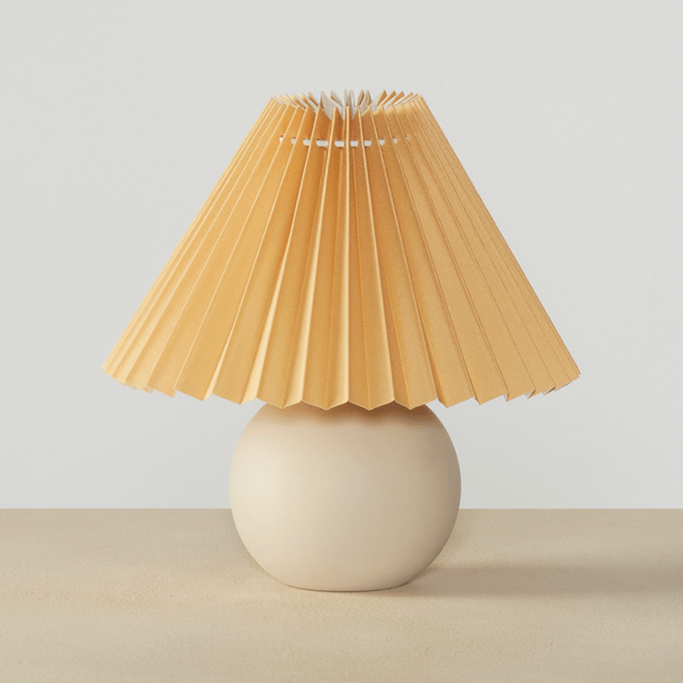 Globe Ceramic Pleated Shade Table Lamp on a neutral concrete tabletop