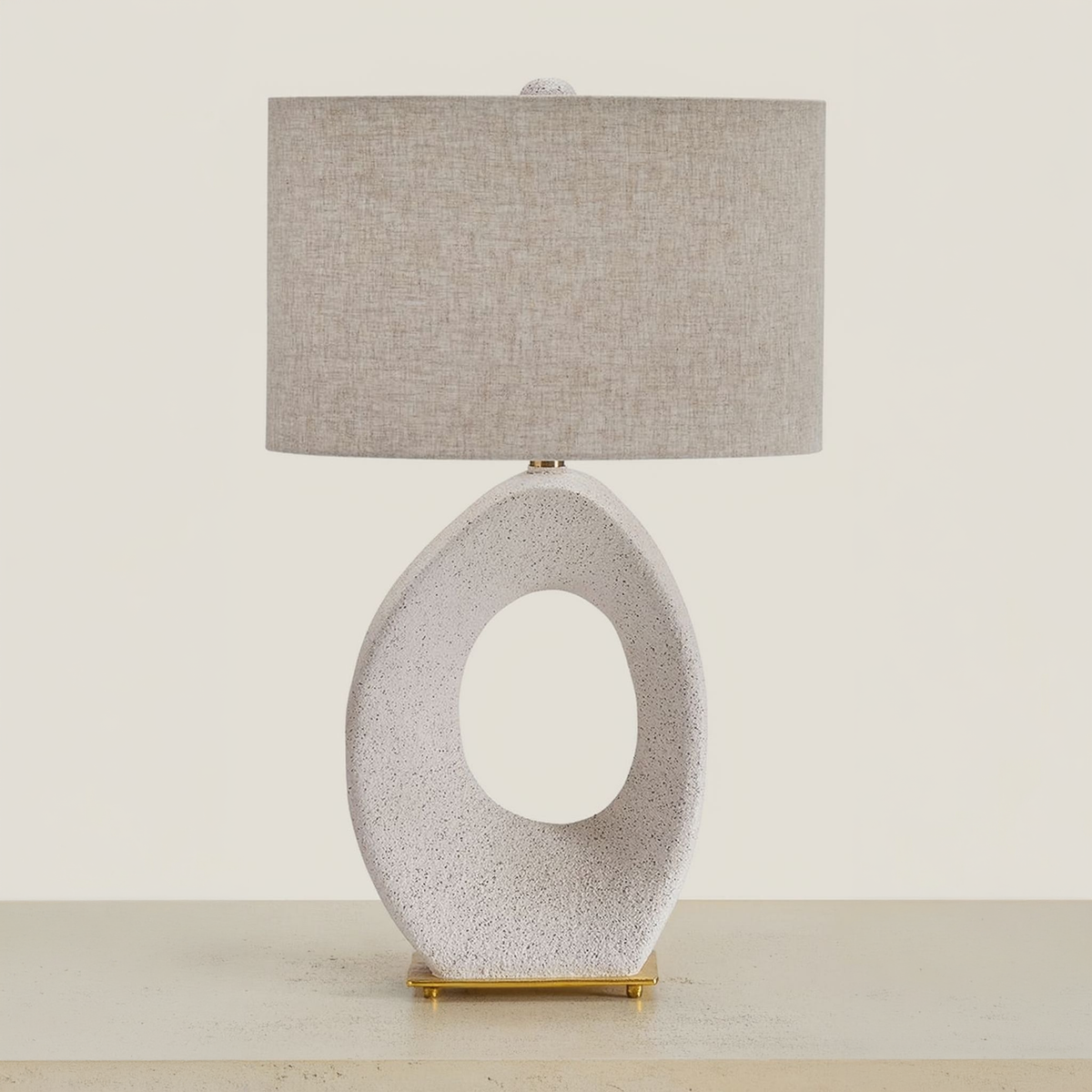 Trentlen table lamp with an open oval cream base and fabric shade