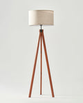 Linen Shade Tripod Floor Lamp — Warm wood-finish tripod with a woven linen drum shade for ambient reading light