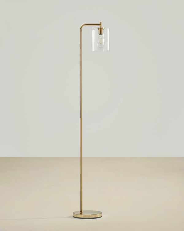 Brass floor lamp with a curved upper arm, clear glass cylinder shade and filament bulb