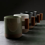 Wood-Handle Glazed Ceramic Mug — Glazed ceramic mug with a blocky wood-grain handle in five muted colorways