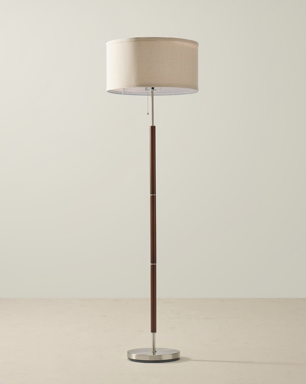Wood-grain floor lamp with a beige linen drum shade, single pull chain and silver round base