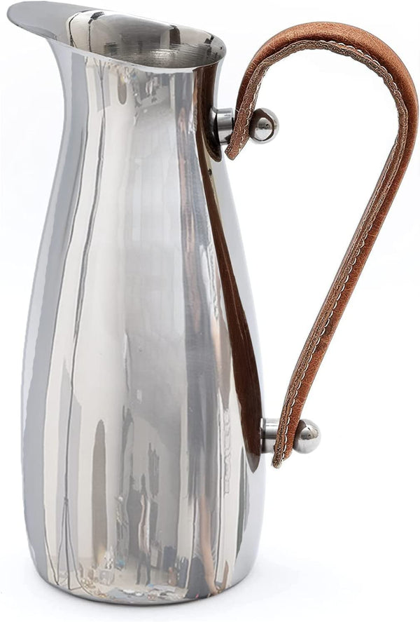 Polished Steel Leather-Handle Pitcher styled on a countertop with fresh botanicals