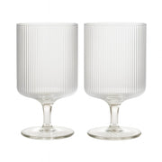 Ribbed Clear Glass Wine Goblets styled with linen bedding in a warm bedroom