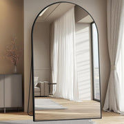 Arched Metal Frame Floor Mirror hung above a console table with ceramics
