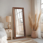 Dark-Stained Wood Floor Mirror hung above a console table with ceramics