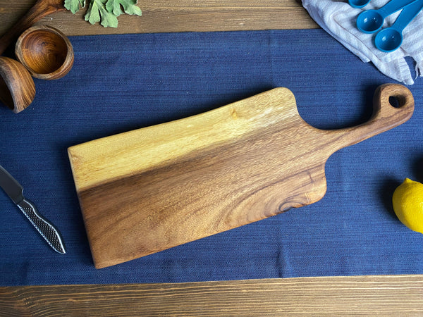 Live Edge Walnut Handled Bread Board styled on a countertop with a sourdough loaf