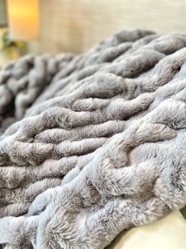 Ruched Faux Fur Throw Blanket draped over a linen sofa arm