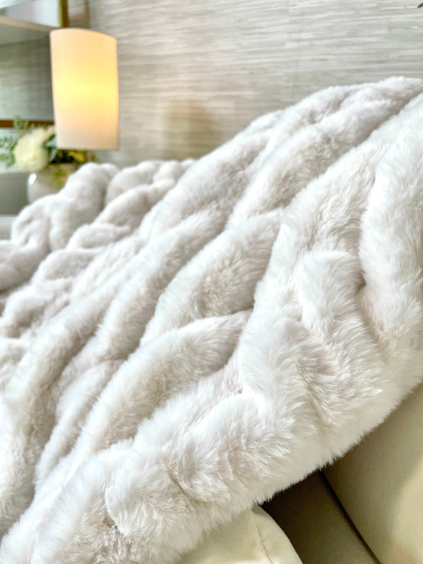 Ribbed Faux Fur Ivory Blanket draped over a linen sofa arm