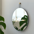 Brass-Hook Round Wall Mirror — Slim-framed round mirror with brushed brass hook and looped dark cord