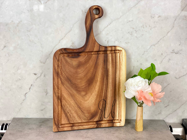 Live Edge Walnut Handled Cutting Board styled on a countertop with bread and linen