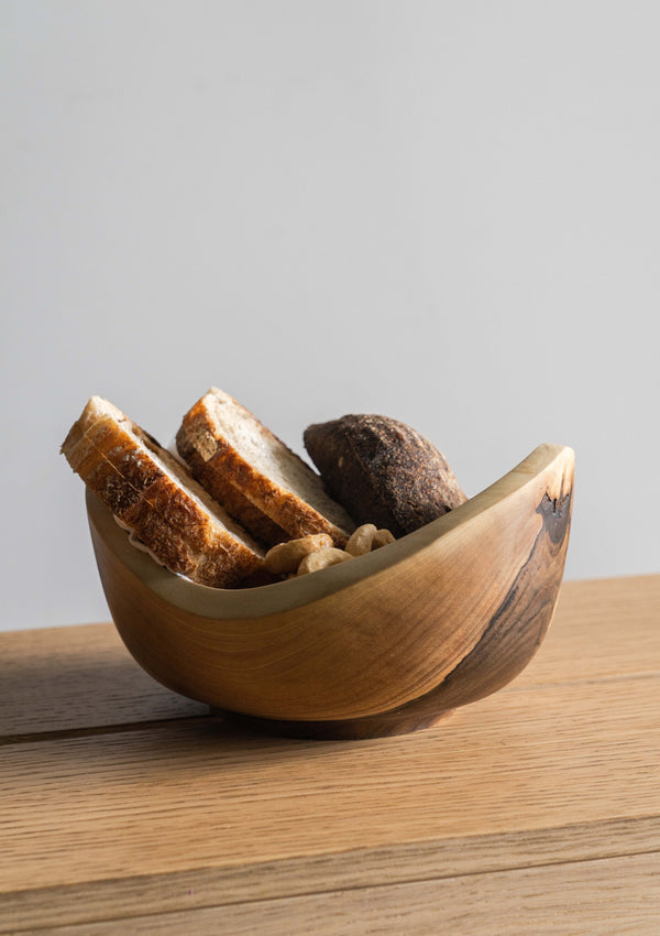 Hand-Carved Walnut Wood Bowl styled on a kitchen counter with produce