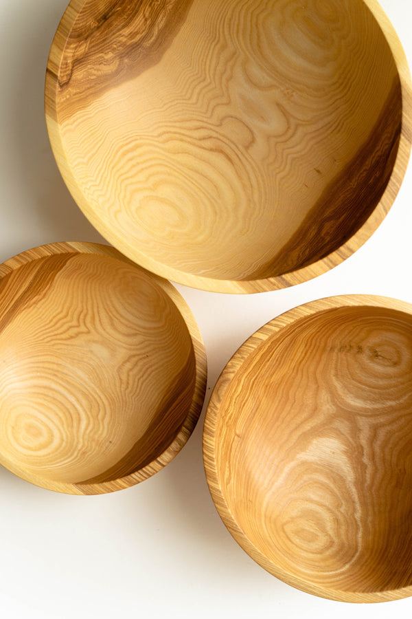 Hand-Carved Wood Nesting Bowl Set styled on a kitchen counter with produce