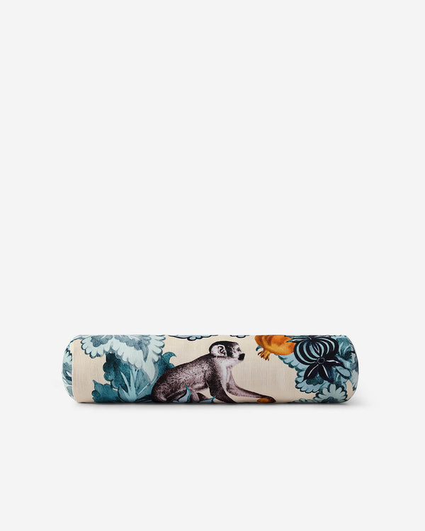 Cream bolster pillow with monkey and floral print in teal, orange, and black, cylindrical