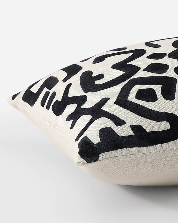 White lumbar pillow with black abstract geometric shapes, lumbar