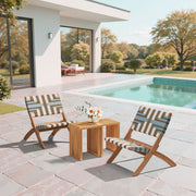 Woven Strap Acacia Folding Lounge Chair styled on a sunlit patio with side table