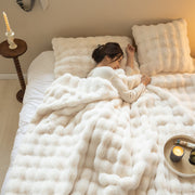 Bubble-Texture Fleece Throw Blanket draped over a linen sofa arm