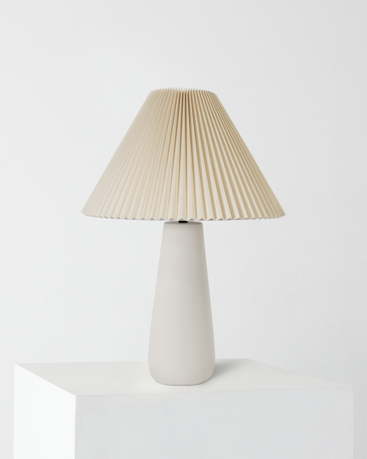 Pleated Shade Ceramic Table Lamp — Tapered ceramic base with a wide pleated shade for warm, diffused light
