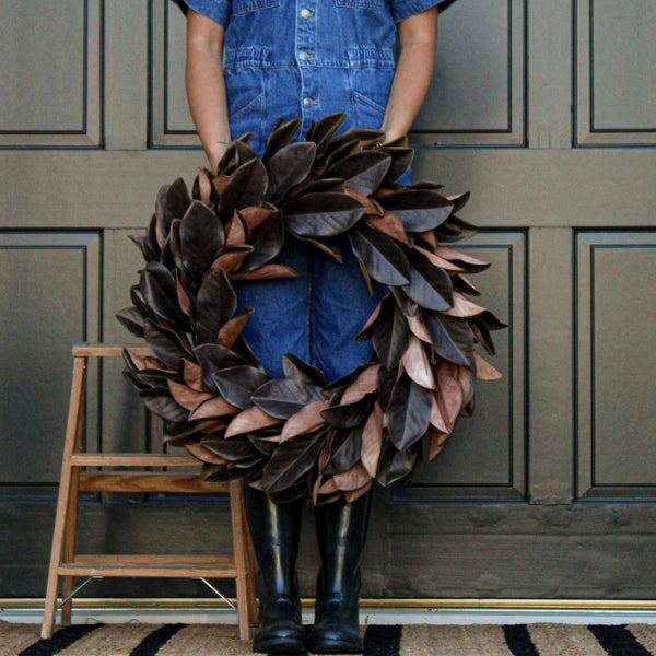 Person holding brown Magnolia Leaf Wreath wreath, circular outdoors