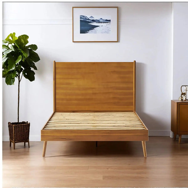 Honey-brown panel-headboard frame without mattress in a bright room with leafy plant.