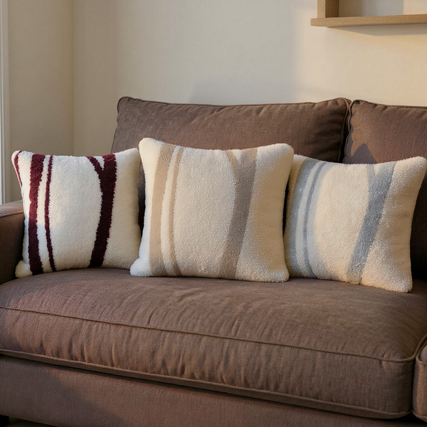 Color options for Bouclé-Texture Woodland Stripe Pillow grouped on coordinated upholstered seating