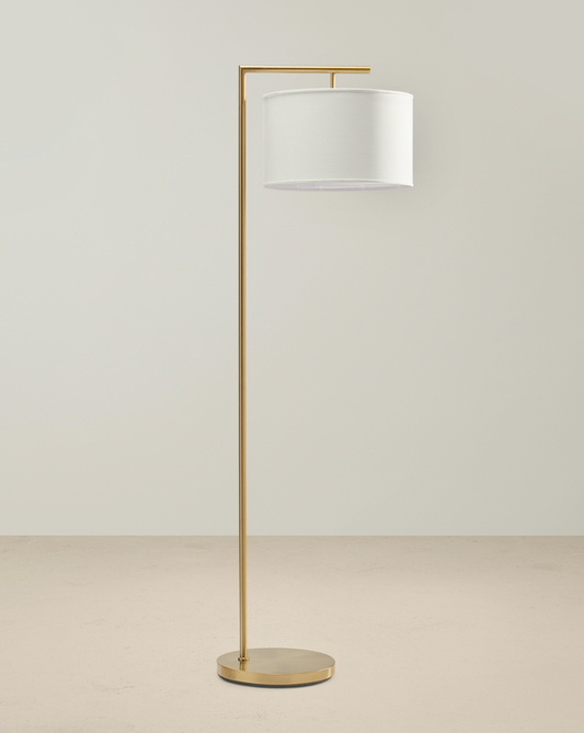 Brass floor lamp with a right-angle arm, white drum shade and round brass base