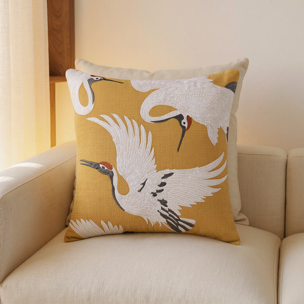 Crane Embroidered Linen-Weave Throw Pillow in a close view on coordinated upholstered seating