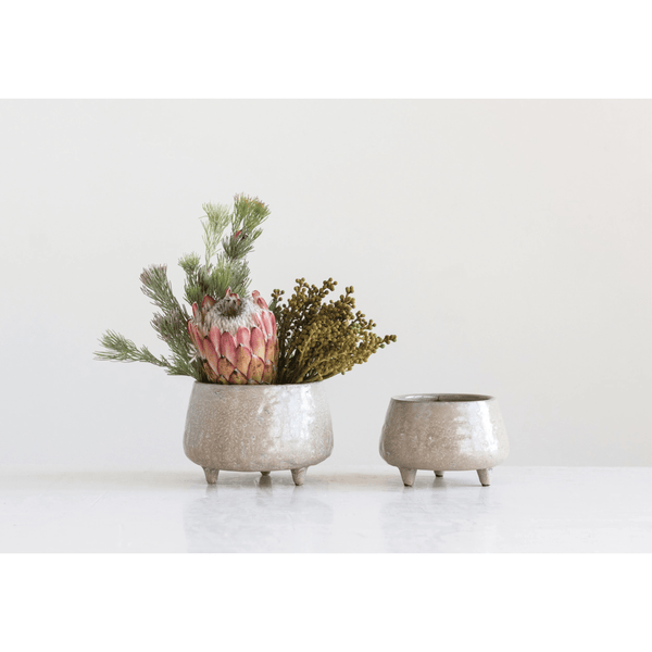 Stoneware Footed Planter with Glazed Finish holding a trailing plant on a patio