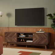 Walnut-tone TV stand with herringbone doors, open shelves and tapered legs in a mid-century modern room with olive walls and walnut paneling