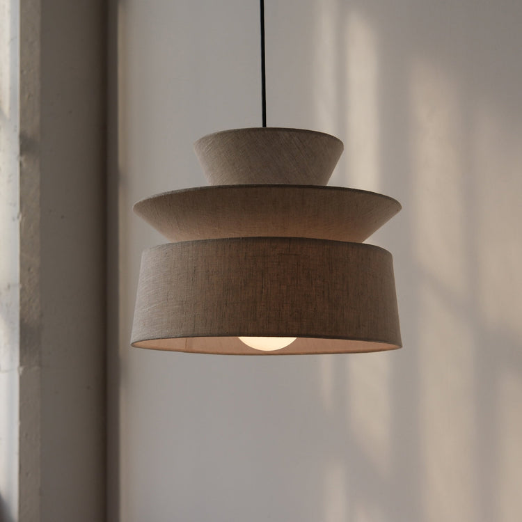 Tiered Organic Cotton Pendant Lamp — Three-tiered organic cotton pendant that diffuses light gently over dining tables and
