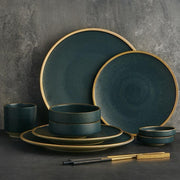 Matte Porcelain Dinnerware Set — Matte porcelain dinnerware with a hand-applied warm gold rim, in deep tonal glaze