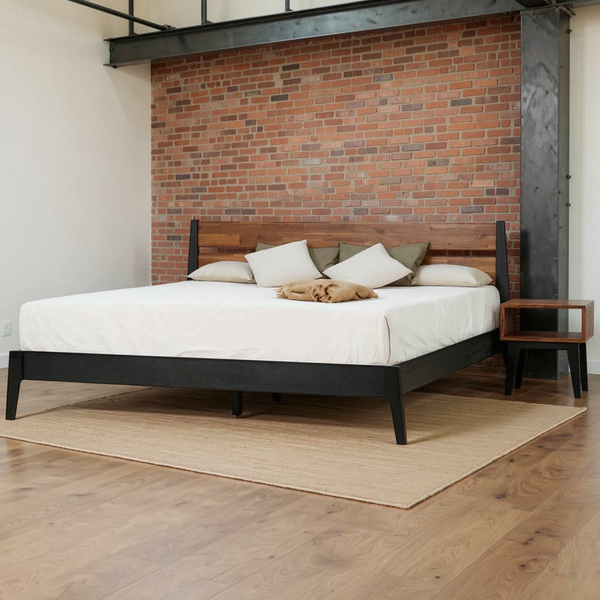 Callisto Solid Wood Bed Frame and Nightstand and its included nightstand in a warm brick and steel loft bedroom with neutral bedding and a flat rug.