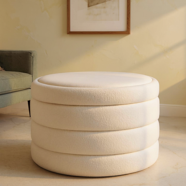 Boucle Round Storage Ottoman on a travertine floor in a sunlit room with cream limewash walls