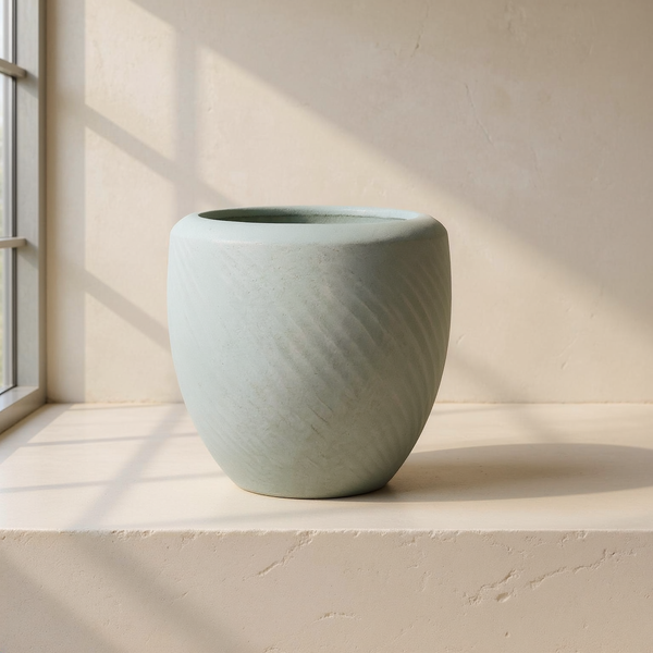 Swirl-Textured Magnesia Planter against cream microcement with warm steel-window grid shadows