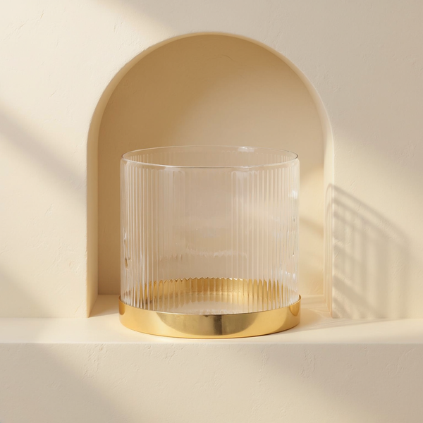 Ribbed Glass Gold-Base Vase in a cream plaster niche with warm natural side light