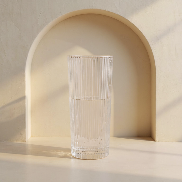 Ribbed Clear Glass Column Vase in a cream plaster niche with warm natural side light