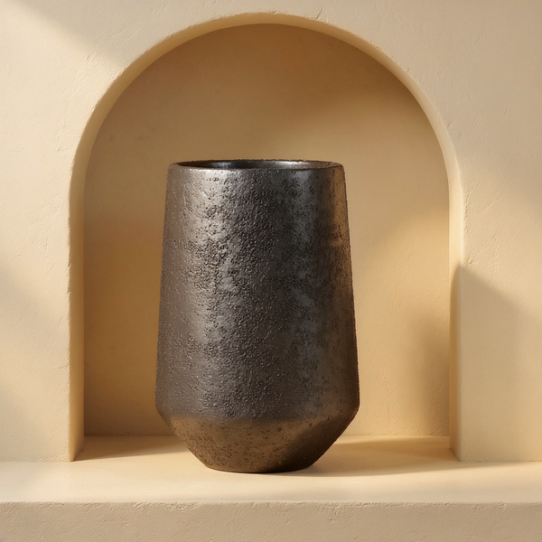 Sand-Cast Aluminum Textured Vase in a cream plaster niche with warm natural side light