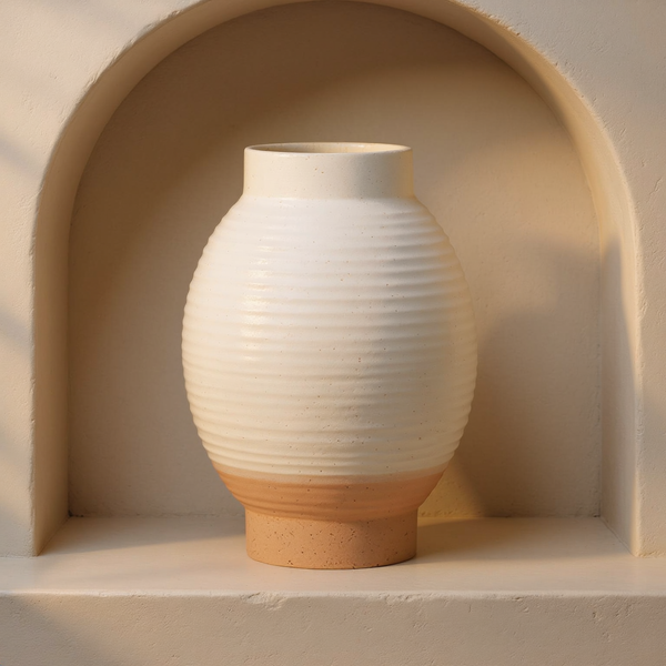 Ribbed Ceramic Short Vase in a cream plaster niche with warm natural side light