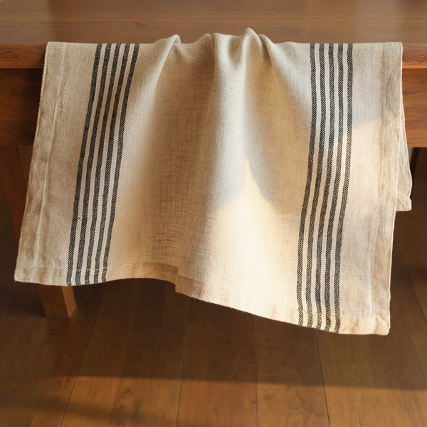 Ivory & Black Striped Linen Napkins, Set of 4 on a walnut table in warm side light
