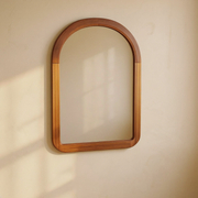 Arched Walnut Wood Frame Wall Mirror against cream limewash with a softly reflected room